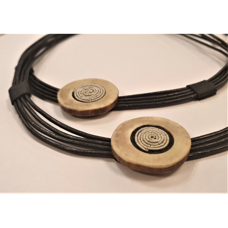 Halsband i svart läder med en detalj i horn broderad med tenntråd