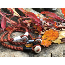 Armband i tvinnat brunt renskinn med hornknapp och detaljer i  svart