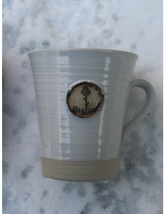 Handdrejad mugg i vit eller gräsgrön glasyr med emblem föreställande Jämtlands landskapsblomma, Brunkullan. 2