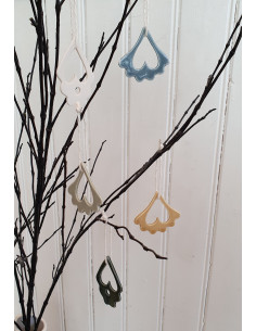 Hängen av porslin i olika färger som hänger i ett björkris