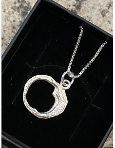 Halsband i silver med en berlock som visar en hålighet som återfinns i Döda Fallet i Ragunda Kommun