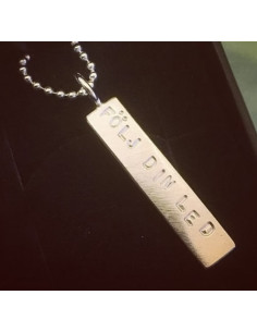 Halsband i silver med en avlång berlock med texten Följ din led instansad 2