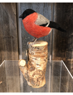 Tovad domherre i färgerna rött, grått och svart som är monterad på en liten stubbe.