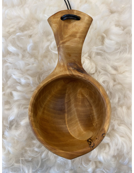 kåsa i trä med vacker melering i materialet coh ett handtag med en lädersnodd till upphängning